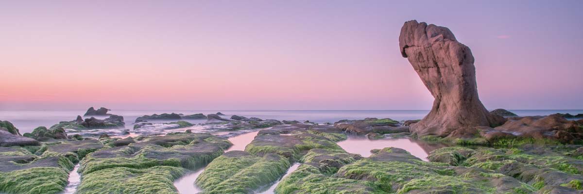 large eroded rock on natural canal filled coastline dreamscape