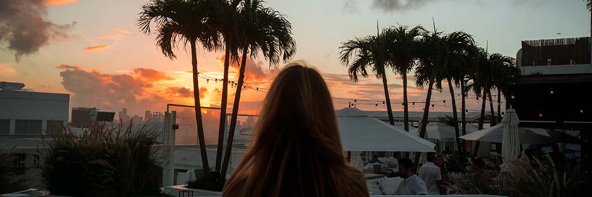 back head of lady looking at beautiful beach resort sunset