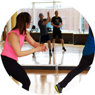 4 people stepping to the right and clapping in a group fitness class