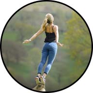 woman balancing on tip of rock