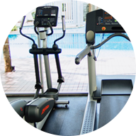 indoor cardio equipment looking out a floor to ceiling winow at an outdoor pool