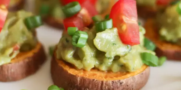 Guacamole on sliced sweet potatoes with garnish