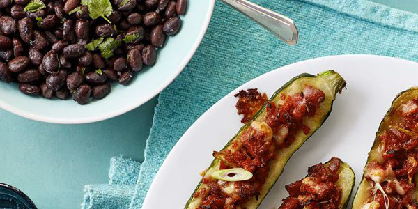 Cheese and back stuffed peppers with a bowl of black beans