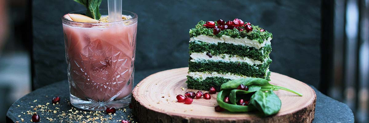 layered spinach cake and red smoothie in short whiskey glass